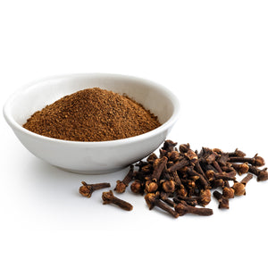 Cloves and ground cloves in a white bowl on a white background